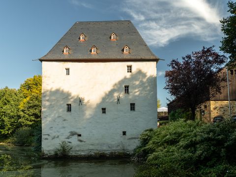 Quadratisches weißes Gebäude mit einem dunklen Dach