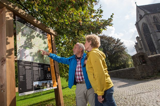 [Translate to Dutch:] Wanderer an einer Infotafel in Altenberg