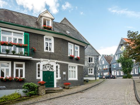 Eine Straße mit Kopfsteinpflaster und einigen Schieferhäusern im Stadtzentrum.