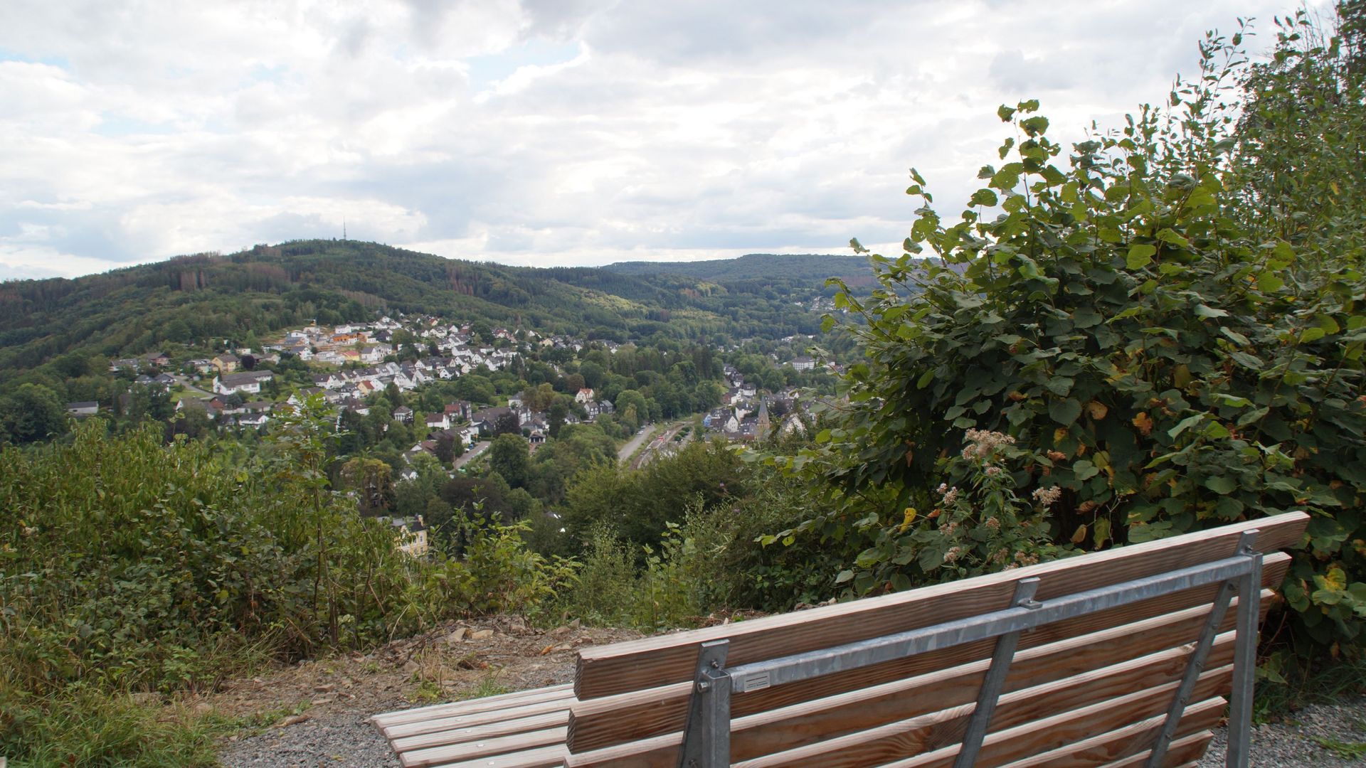 An einem Aussichtspunkt steht ein hölzernes Waldsofa, von dem auch man über das Aggertal schaut.