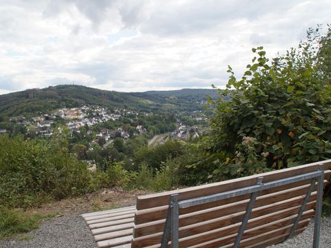 An einem Aussichtspunkt steht ein hölzernes Waldsofa, von dem auch man über das Aggertal schaut.