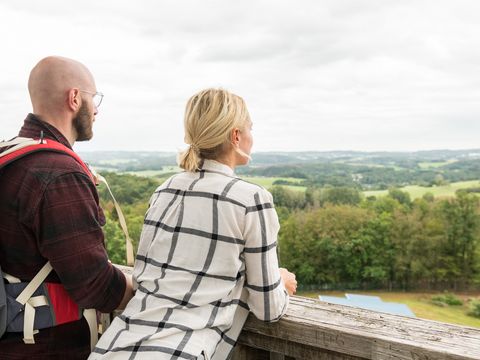 Ein junges Paar schaut vom Aussichtsturm aus über die oberbergische Landschaft.